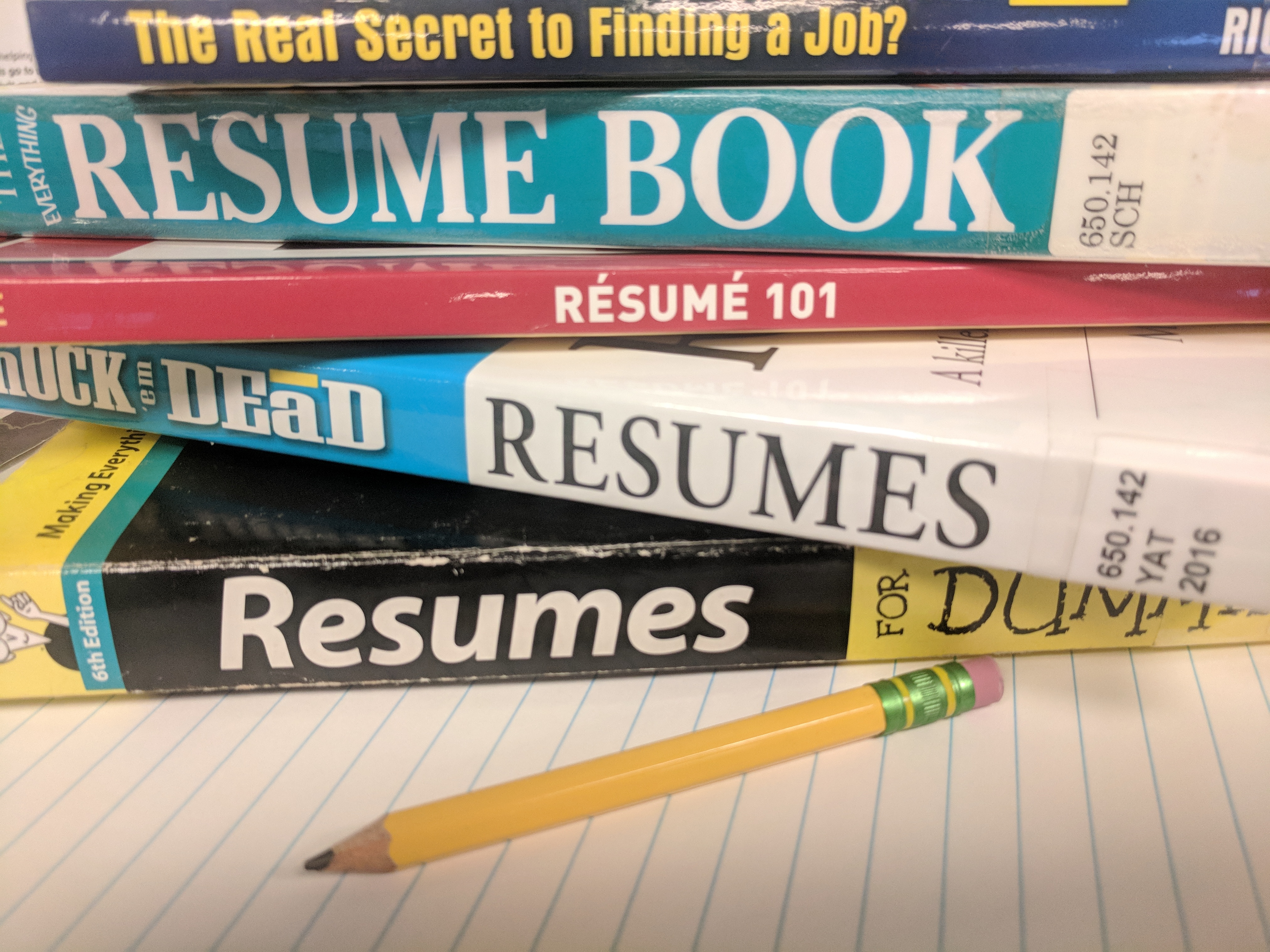pencil paper and stack of resume books