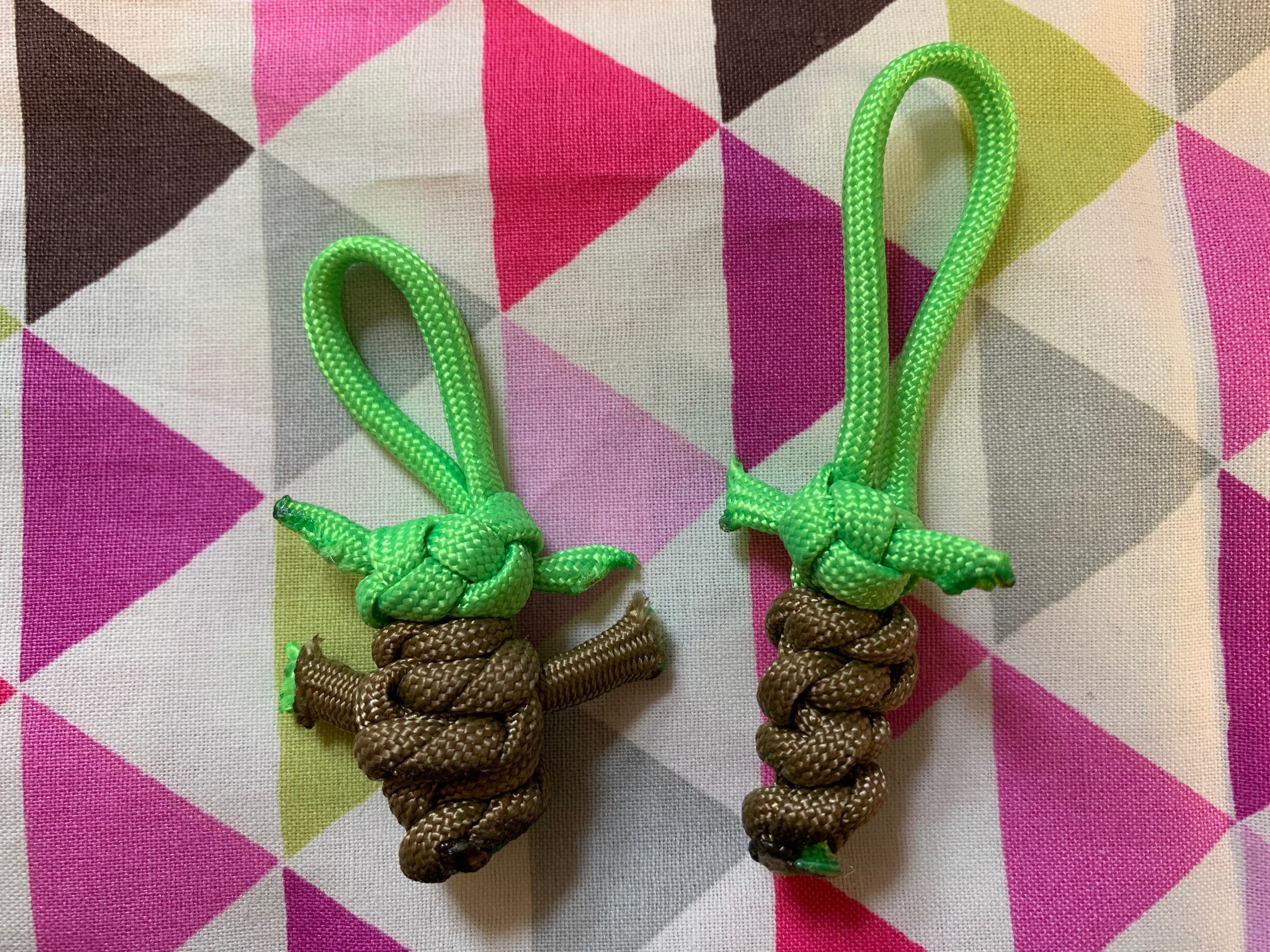 two baby yoda keychains made from green and brown paracord