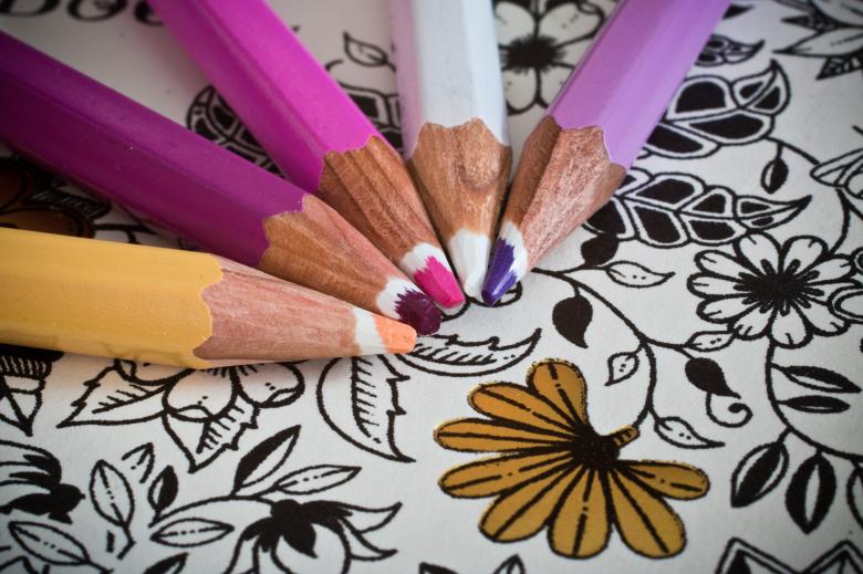 Several colored pencils on top of a coloring sheet
