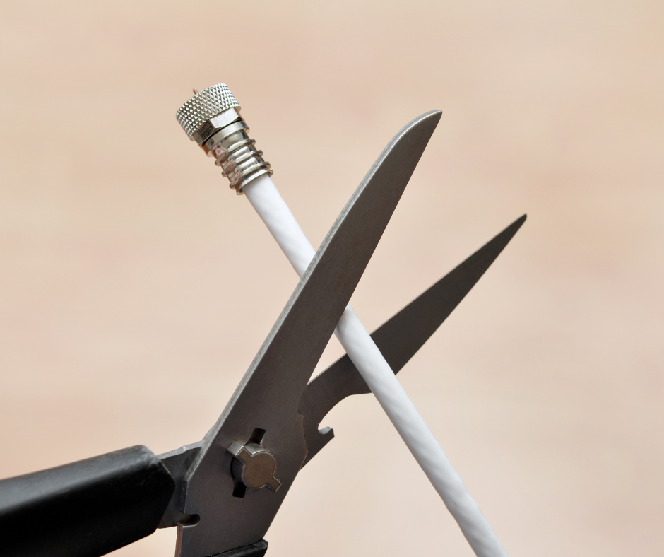 A pair of scissors cutting a TV cable
