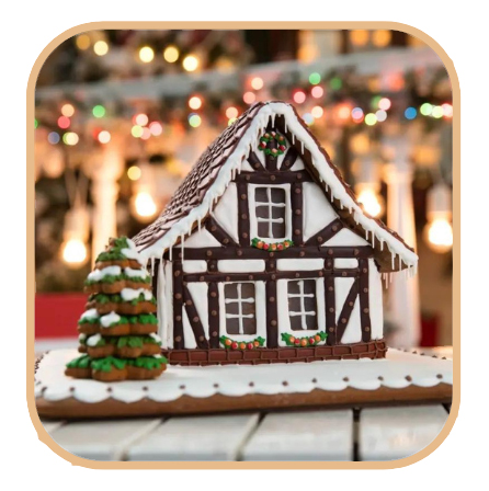 A picture of a gingerbread house in the foreground. Out of focus christmas lights of all colors illuminate the background.