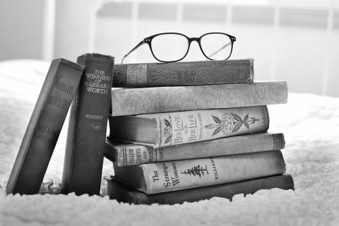 stack of books topped with glasses