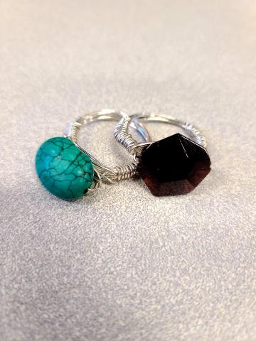 Two silver wire rings with stones on a speckled background