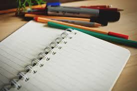 Image of an open notebook and pencils