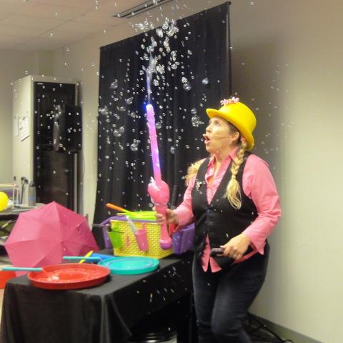 Shelly McBubbles holds a bubble wand, with bubbles coming out of the top.