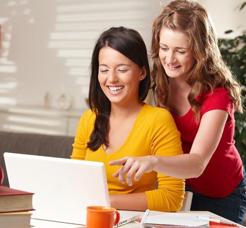 Two women using computer.