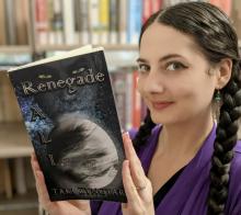 Author Taki Zyngtara holds a copy of her book, "Renegade"